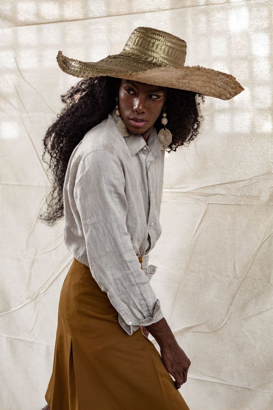 Woman in a straw hat and linen shirt
